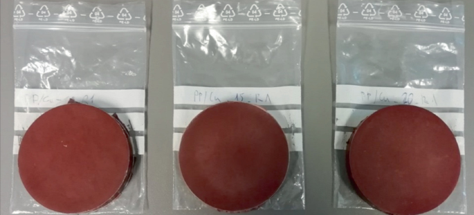A photo of 3 different samples for measuring thermal conductivity. The samples are circular in shape and are placed on top of thin polythene cover. The labeling for identification of the samples ae stuck on the cover.