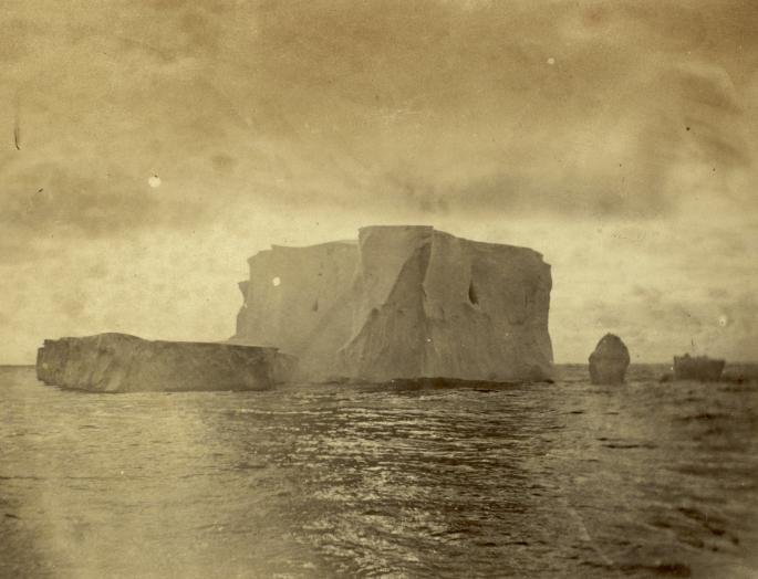 A photograph of a huge iceberg surrounds with water.