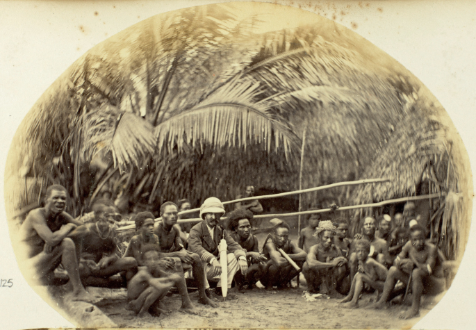A photograph displays crew members sitting together on an island. In the background, palm trees are visible.