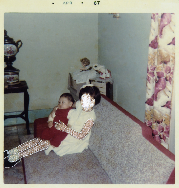 A photograph of a young girl sitting on a sofa with a baby on her lap.