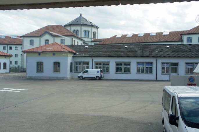 A photo captures a van standing in front of a long house.