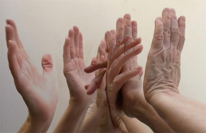 A photograph of five hands that are ready to clap.