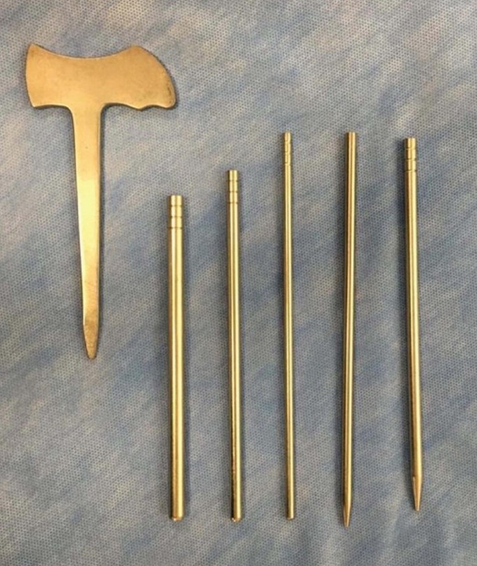 A photograph of a T-shaped blunt muscle detacher next to five tubular-shaped serial dilators. Some dilators have pointed tips, and some have blunt ones.