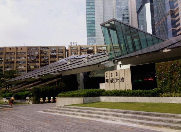 The picture displays C I C zero carbon building in Hong Kong with sets of solar panels on the roof, and the entrance of the building.