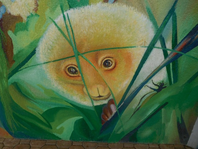 A painting of Cuscus peeking between a bush.