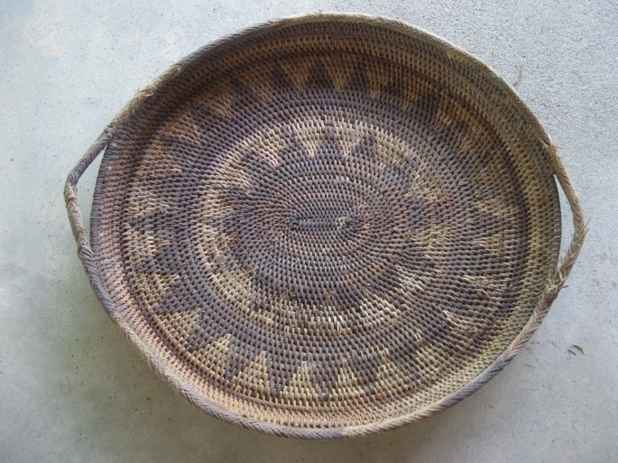 A photograph of a utility basket with a handle made of tree fiber.