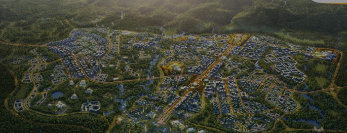 A top down photograph of the forest city. The photo displays buildings, trees, roads, and pathways.