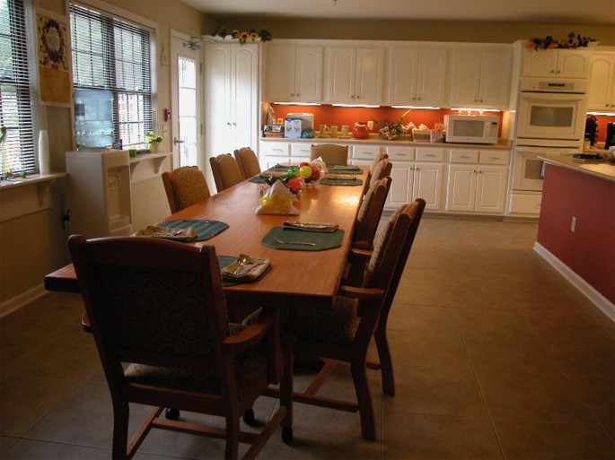 The photo has an 8-seater dining table in an open kitchen.