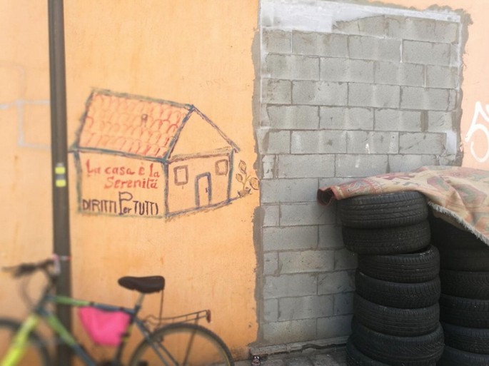 A photo of a door bricked up after the eviction of the squat's buildings. A house is sketched on the wall.