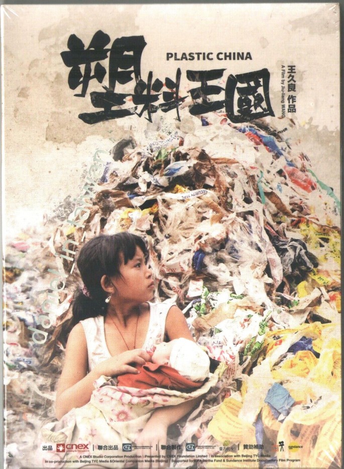 A film poster. It is titled, Plastic China, in English and Chinese. A girl in a pinafore, sits in front of a massive pile of plastic, with a baby on her lap. She turns her head to the right and gazes at a distance.