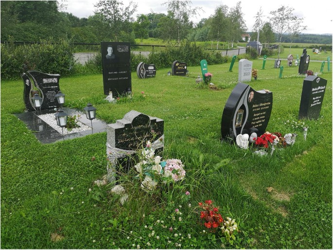 A photograph of a section at Skoger cemetery. It has multiple graves with different headstones.
