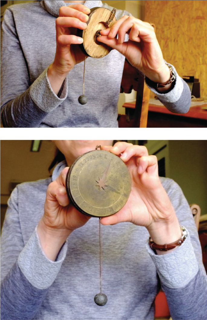 2 photos. 1. A woman holds the dial, exposing the dial's underside. She holds a knob at its center between her thumb and forefinger. 2. She holds the dial, exposing its front side. It has a star emblem at its center, the values clockwise around it, along with a lead ball on a thread, hanging from it.