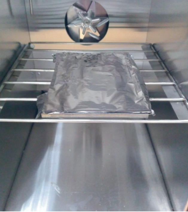 A photograph of polymer samples wrapped in aluminum foil and placed inside a drying chamber.