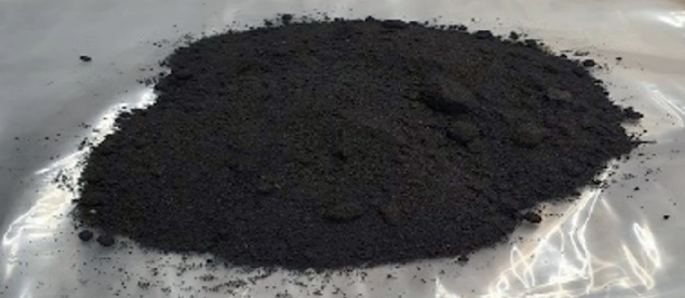 A photograph of waste foundry sand in a dark shade. It is placed over a plastic sheet.