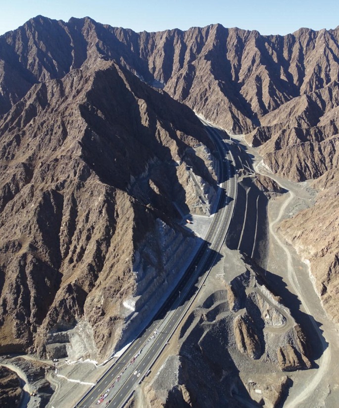 An aerial photo of the Hajar mountains with the highway through the middle.
