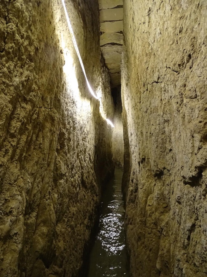 A photo of an underground irrigation system with stone walls.