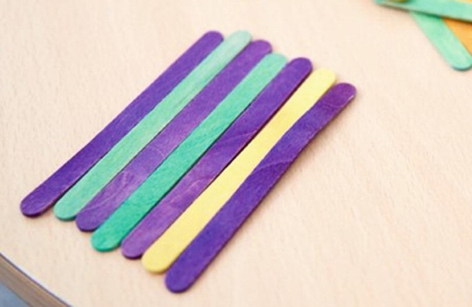A photograph of 7 colorful sticks placed alternately on a table.