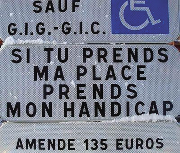 A photo of a sign. It has the handicap icon on it. Text in foreign language.