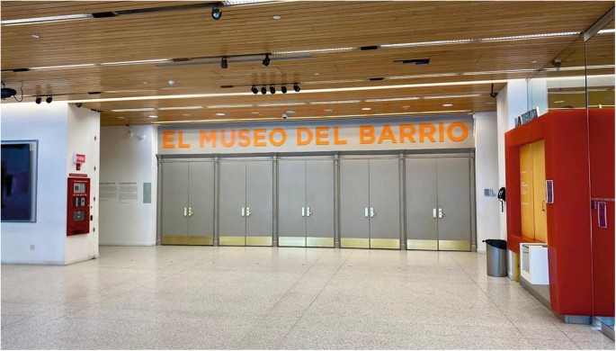 A photograph of the building, which has a wooden interior design, several cameras, and lobby cupboards. It has text written in a foreign language in its entrance.