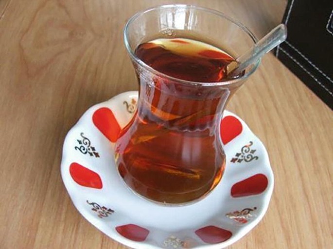 A photograph of a Turkish teacup with tea, placed on a saucer.