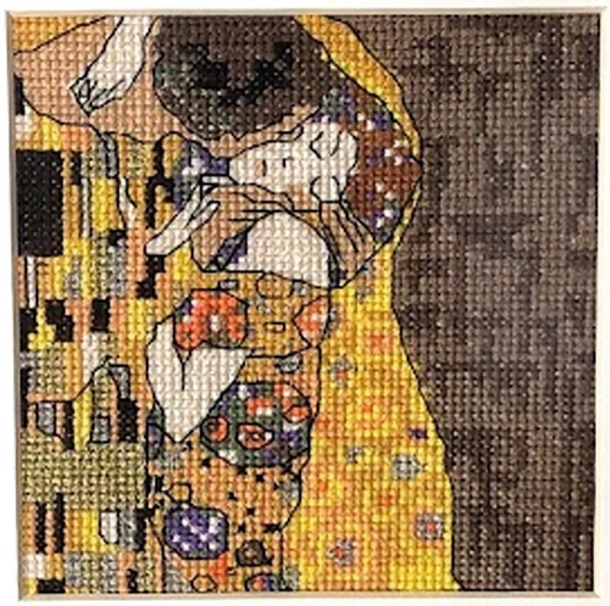 A photograph of a hoop stitch embroidery. It depicts a man kissing a woman.