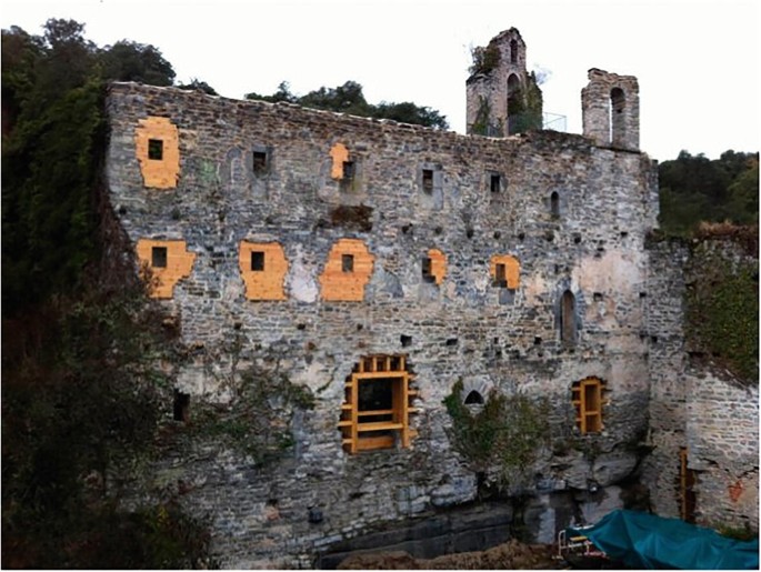 A photo of the restored Santa Catalina de Badaya. It has damaged walls and broken windows.
