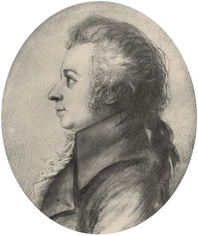 The drawing presents a left-side view of Wolfgang Amadeus Mozart with fine, blond hair and a small braid. His left eye opens wide, and he stares at something.