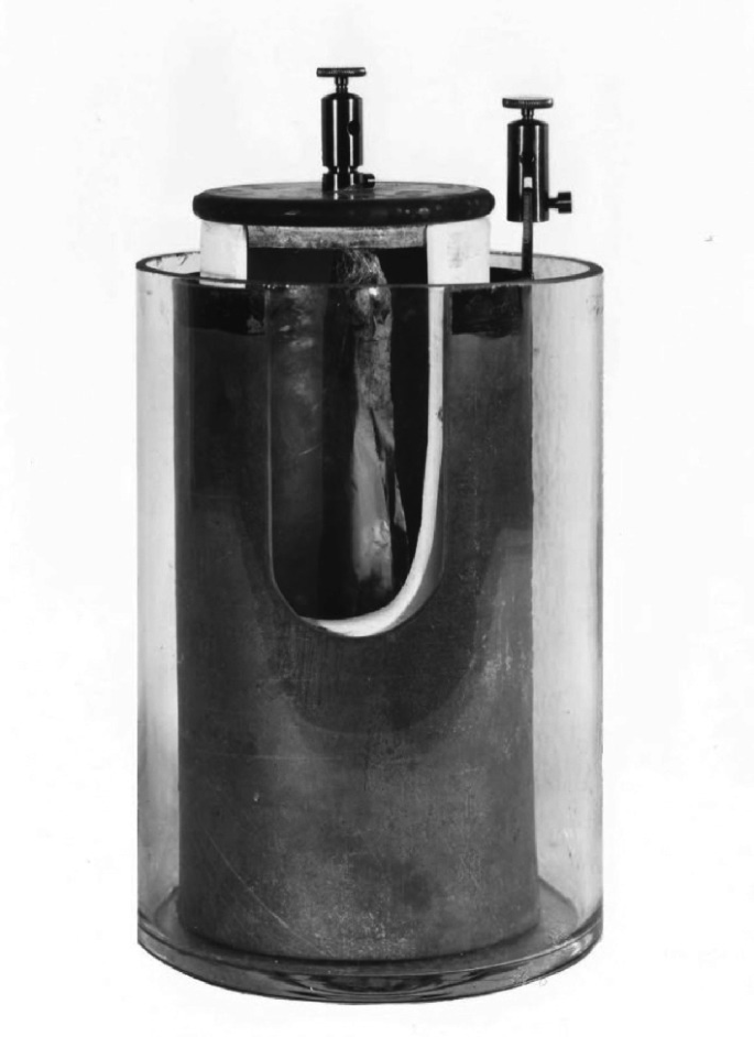 A photo of a cylindrical Grove cell with 2 electrodes in different compartments.