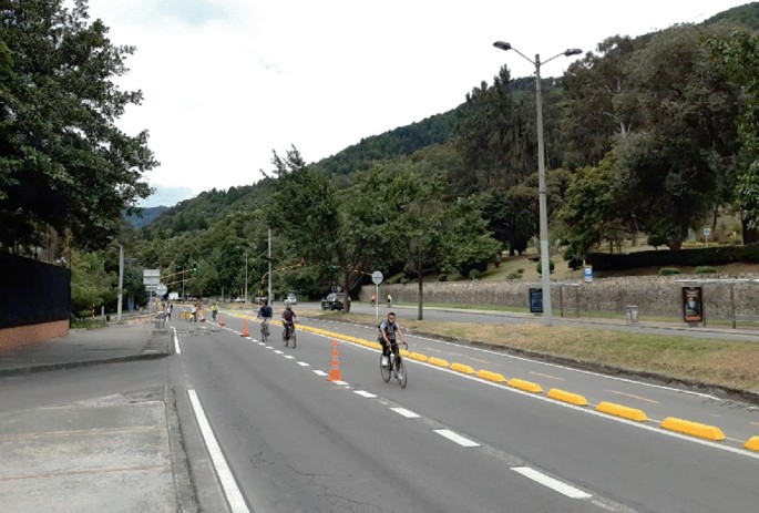 A photograph of cyclists riding in the Avenue Septima in Bogota. The road has a pop-up track to the left.