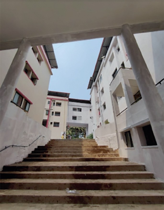 A photograph of the bottom view of Veekay part apartments imposing buildings and a prominent staircase serving as the entrance.