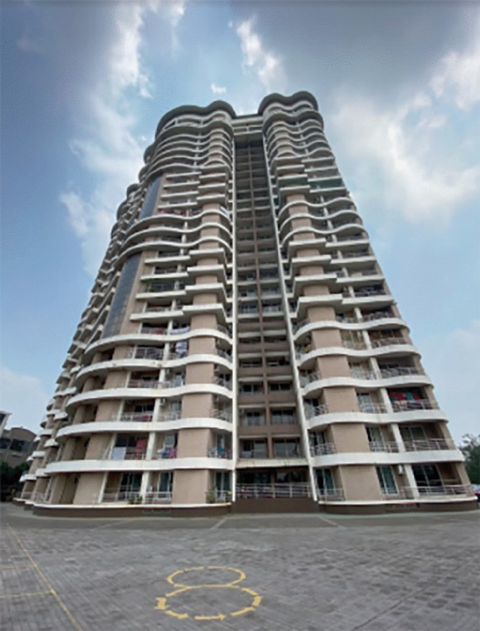 A bottom view photograph of the multi-storey Inland Windsor apartment with a road in the foreground.