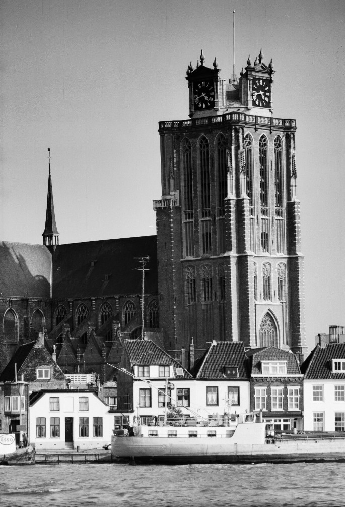A black and white photo of the Tower of Our Lady, a large building with a ground plan of at least 15 by 15 meters, located in Dordrecht, Netherlands.