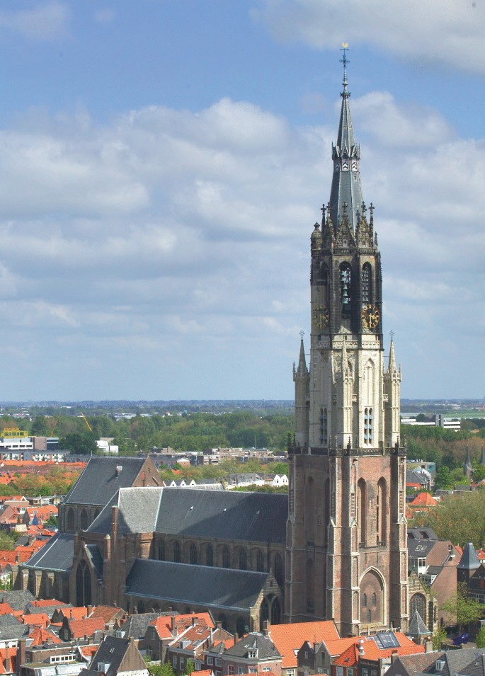 A photo of the tower of the New Church in Delft presents a large church tower with a tall, slender spire.