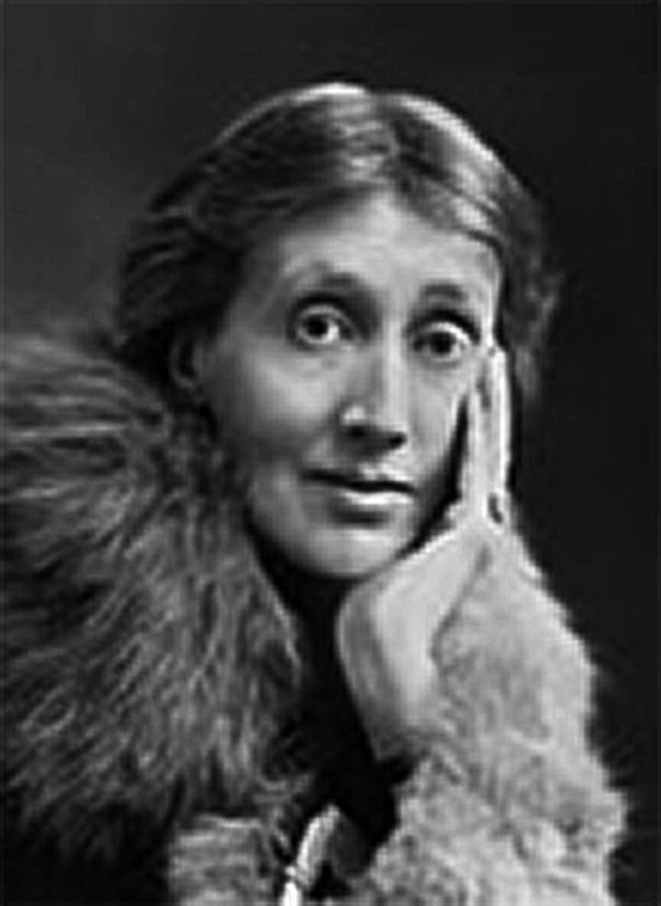 A close-up photo of a woman with large eyes and a long face. She wears a furry jacket and rests her hand on her right cheek.
