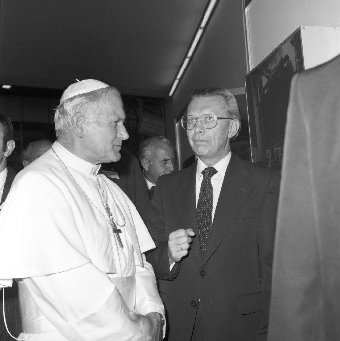 A photograph of Herwig and Pope John Paul 2 having a conversation. There are several people in the background.