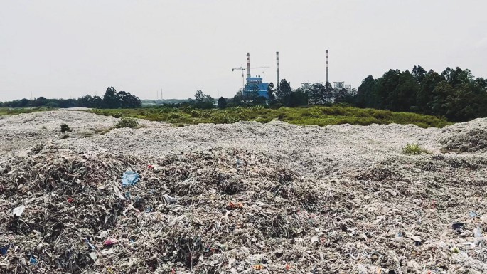 A photo of a large mound of plastic waste dumped on a landfill.