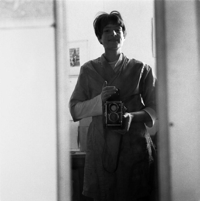 A photograph of Joanne Leonard holding a camera in front of a mirror.