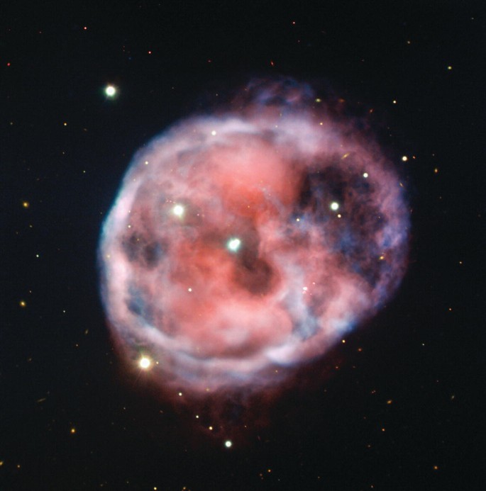 A photograph of a planetary nebula. It looks like a spherical shell of gas. The bright dots are spread over it.