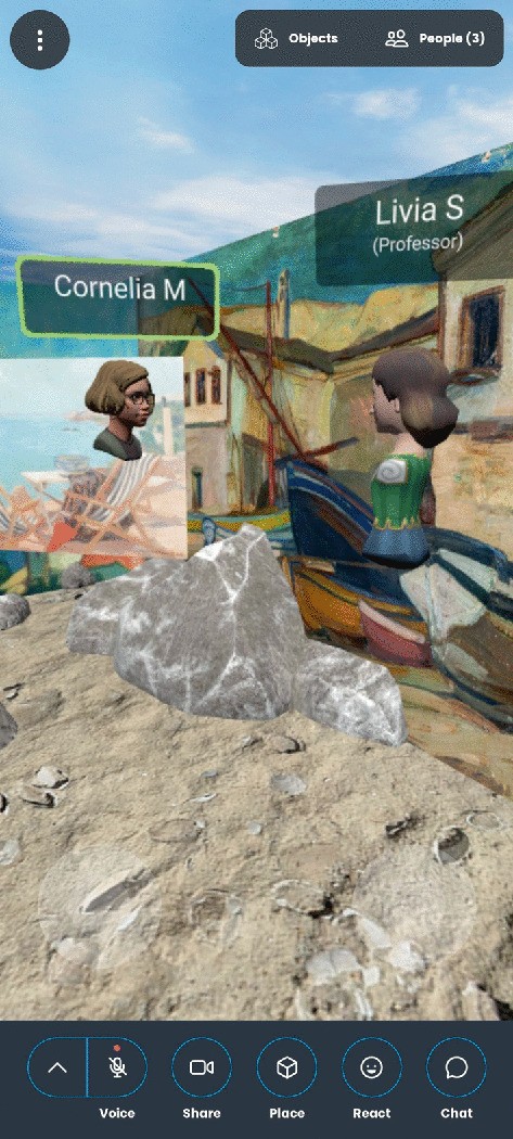 A screenshot of a V R environment on a mobile application. Two 3-D avatars named Cornelia M, and Livia S the professor face each other in front of a wall with murals on a rocky surface, with a coast in the background. The bottom panel has voice, share, place, react, and chat icons.