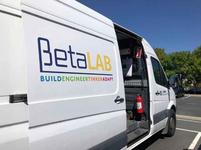 A photograph of a van with a logo on the side that reads Beta Lab, build, engineer, tinker, adapt.