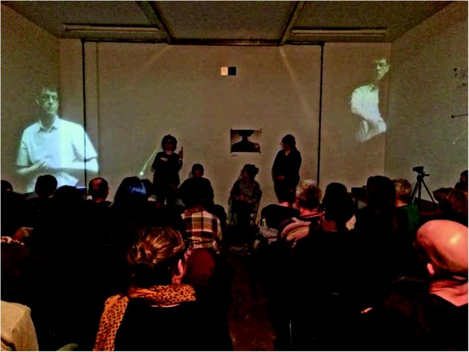 A photograph of a woman conducting a question-and-answer session with the audience.