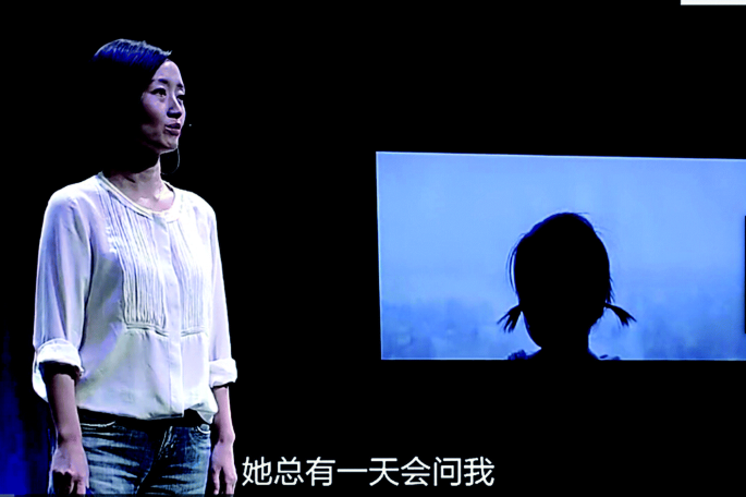 A photograph displays Chai Jing, who stands near the presentation screen. The screen displays a girl who stands near the window and peeks at the heavy smog.