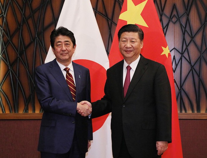 A photo of the handshake moment between Shinzo Abe and Xi Jinping.