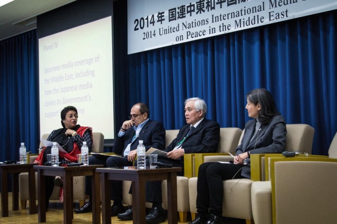 A photograph of two men and two women who are engaged in a discussion during a United Nations, International Media Seminar on Peace in the Middle East in Tokyo in 2014.