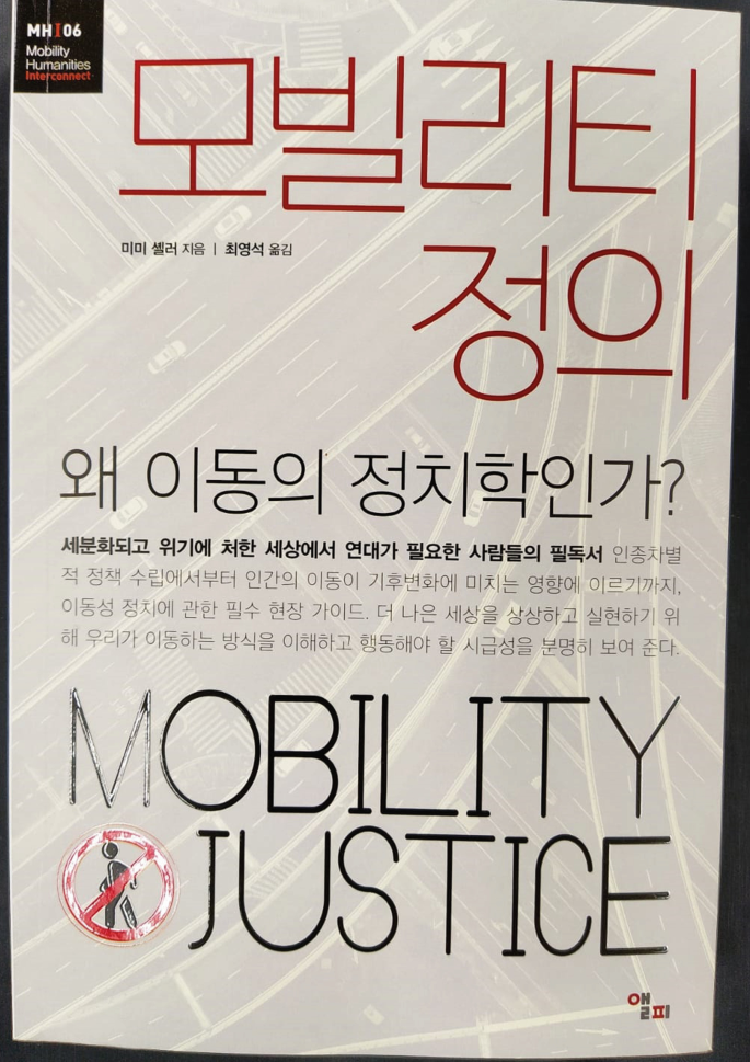 A front cover of a book reads, mobility justice. The other texts on it are written in a foreign language.
