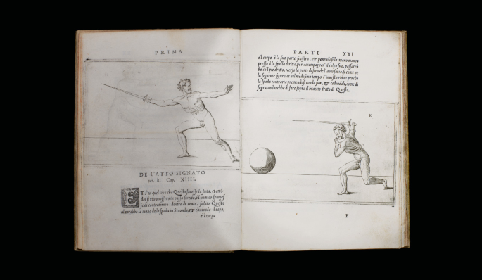 An opened book. The sketch on the left page has a man half seated with a sword in his hand and a paragraph written below it. The right page has a paragraph written on top and a sketch of a large ball and a man kneeled down with a sword in his hand at the bottom. The left page is titled P R I M A and the right one is titled P A R T I.