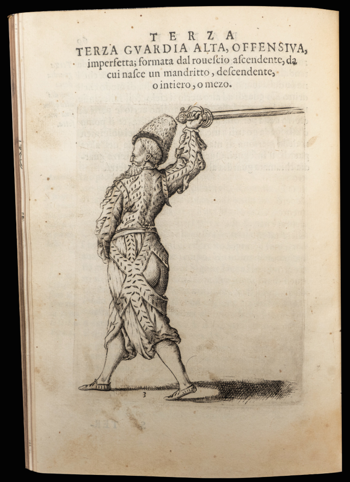 A page of an old book with the title T E Z R A and a sketch of a man in his metal armor. One of the hands of the man has risen with a sword in it.