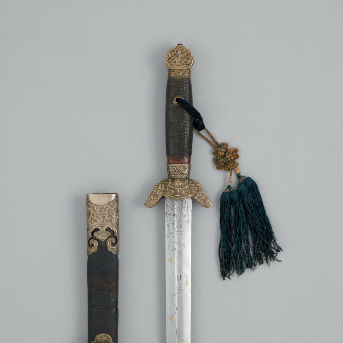 A magnified view of the sword guard and the scabbard from the Qing dynasty. The sword has a zoomorphic guard with wings that point downwards.