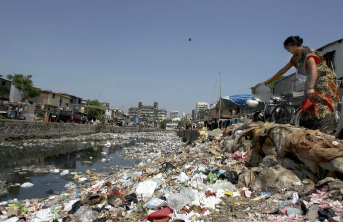 A photograph depicts the municipality solid waste running over a water course.