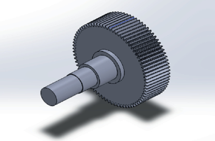 An image depicts output shaft and gear. Top part of the gear depicts a circular flat shaped shaft, and the bottom part is of cylindrical shape.